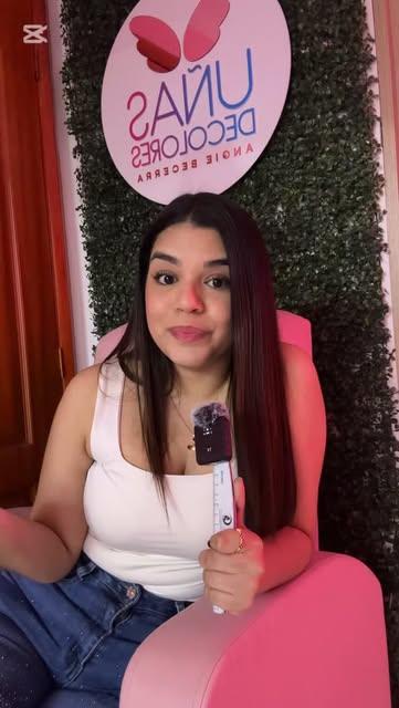 Angie Becerra en su estudio, frente al letrero de Uñas de Colores