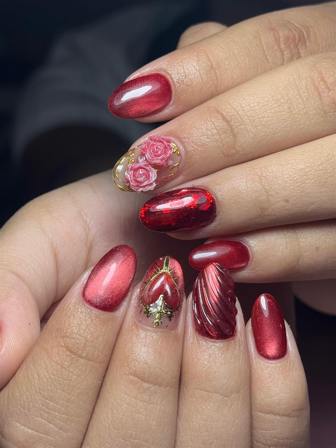 Uñas rojas efecto espejo con rosas en relieve